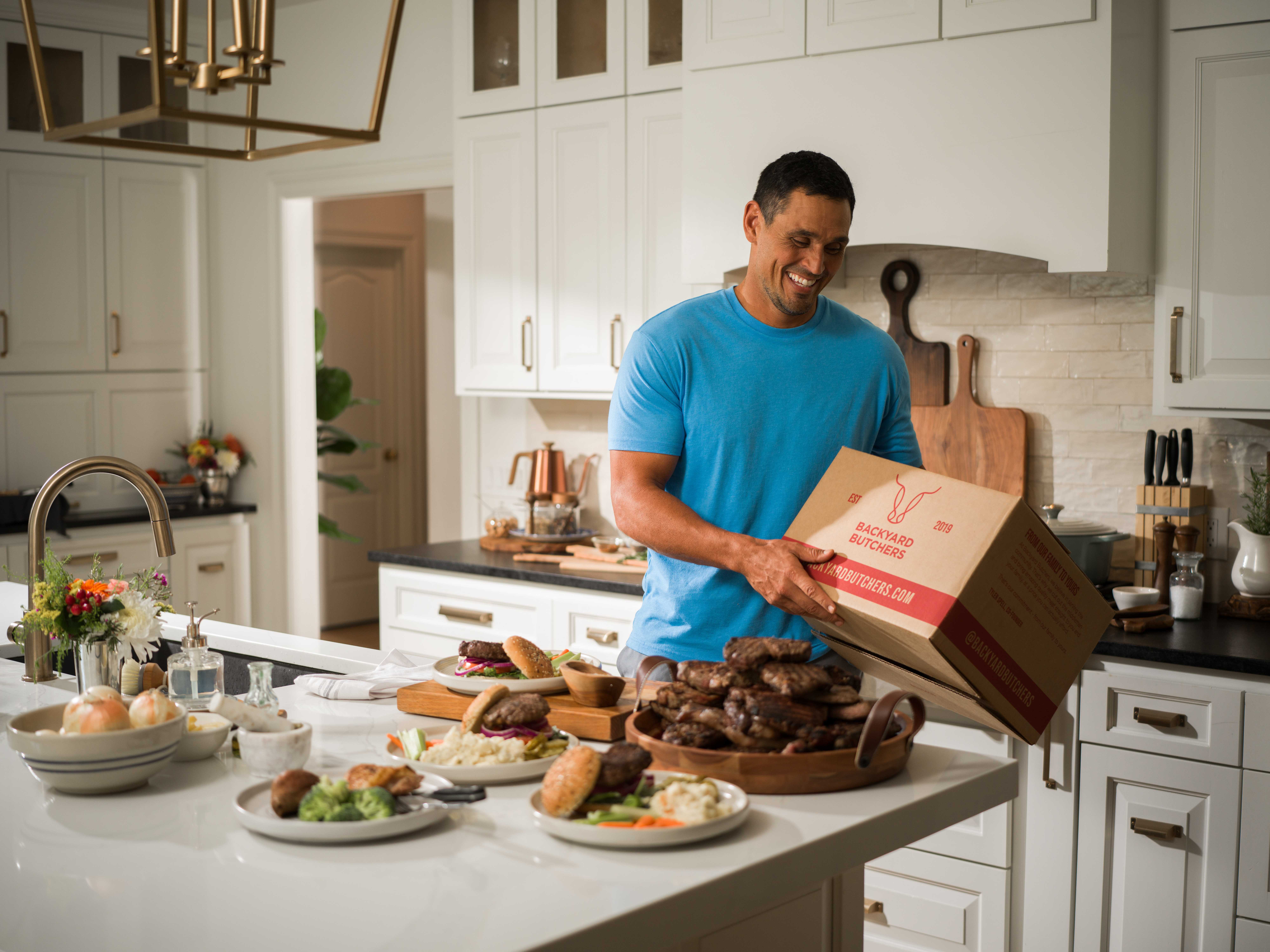 David Pollack — David in the kitchen, unpacking a box next to a platter of steaks.